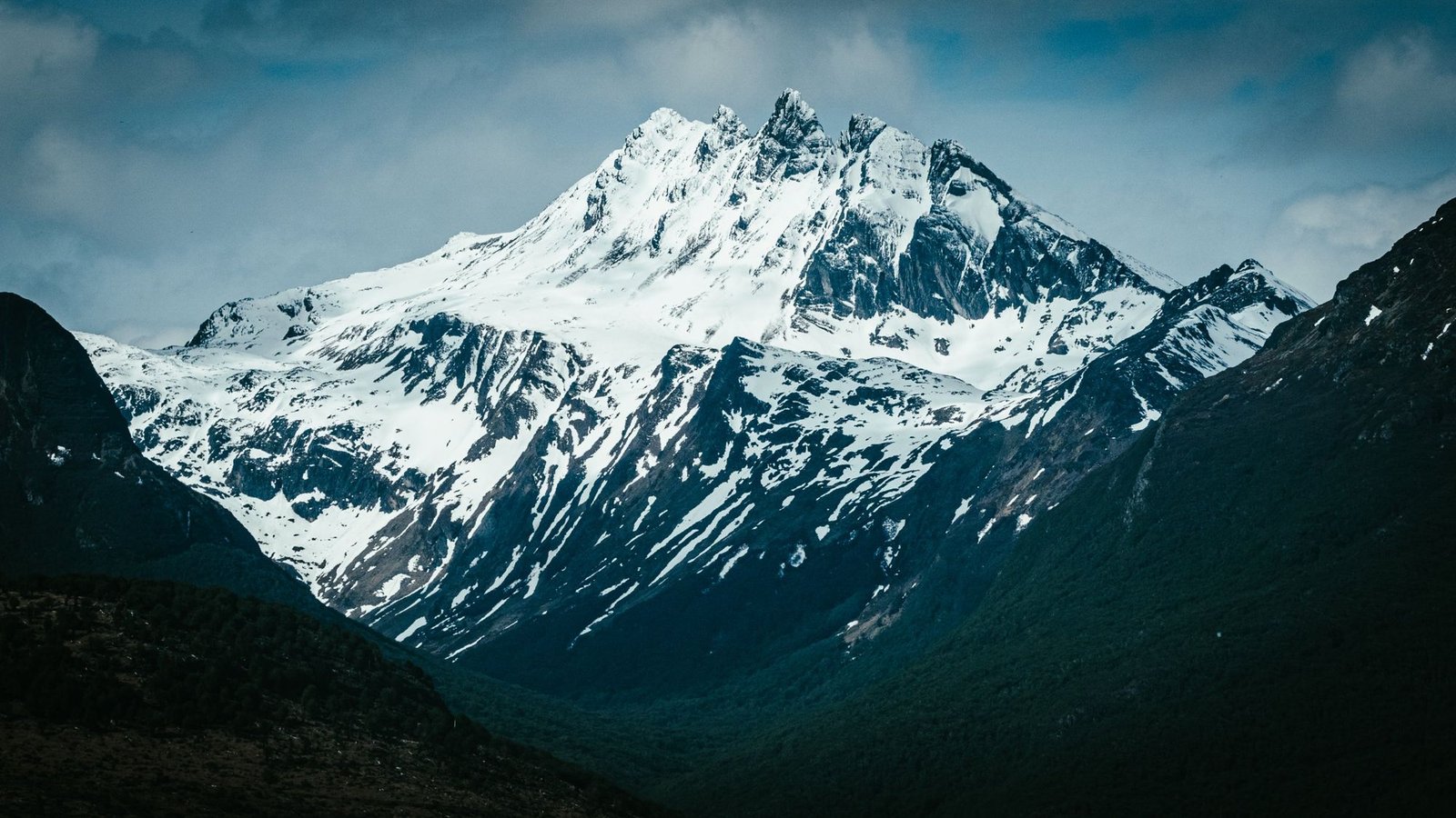 Pico nevado entre montañas